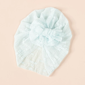 Close-up of light blue baby turban with textured dot fabric and oversized mesh bow