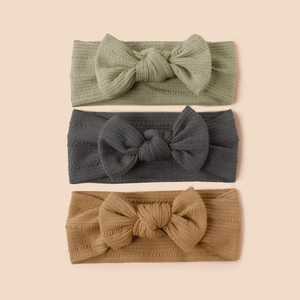 Three-piece set of ribbed knit baby headbands with bows in sage, charcoal, and ginger
