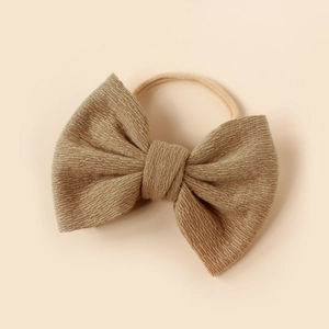 Detailed view of khaki knitted bow headband with ultra-soft nylon elastic band for babies