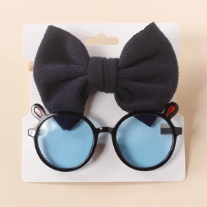 Detail of baby headband with navy bow and cute bunny ear sunglasses set on card