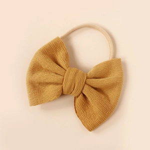 Macro view of mustard yellow knit bow texture on super soft nylon baby headband