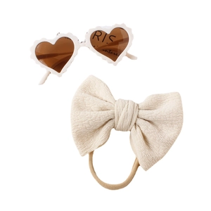 Two-piece baby accessory set featuring white heart sunglasses and a knit bow headband