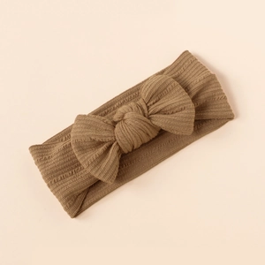 Detail showing soft ribbed knit texture and handmade bow on the baby stretch headband