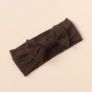Close-up of soft ribbed dark brown baby headband with a large decorative bow