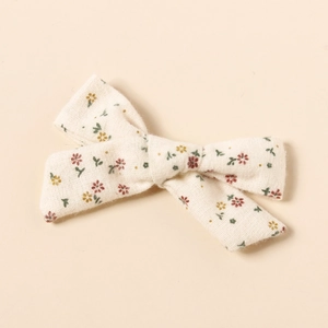 Vue détaillée de barrettes à nœud en coton avec des motifs de fleurs vintage délicats