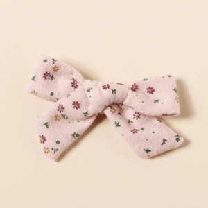 Détail de la pince à cheveux nœud à motif floral rose en tissu de coton texturé