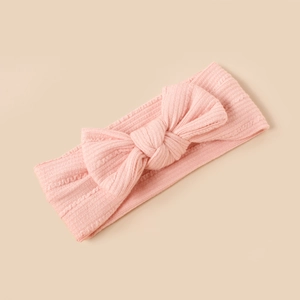 Detailed view of pink ribbed knit baby headband with a soft oversized bow design