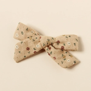 Détail d'une pince à cheveux nœud floral vintage en coton avec motif marguerite