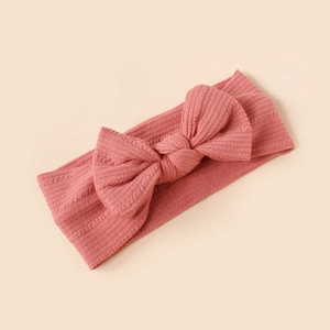 Close-up of pink ribbed fabric baby headband with a large decorative bow
