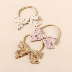 Detailansicht von drei Baby-Stirnbändern aus Nylon mit verschiedenen Blumenmustern