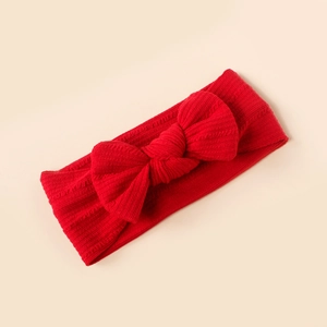 Detail of red striped knitted baby headband with a large soft bow decoration