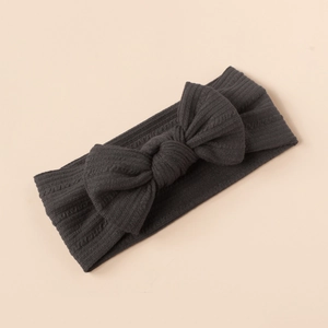 Close-up of dark grey ribbed knit texture and large bow on soft elastic baby headband