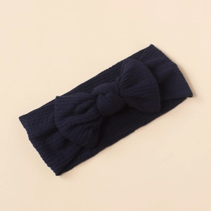 Detailed view of dark navy ribbed knit baby headband with a large decorative bow