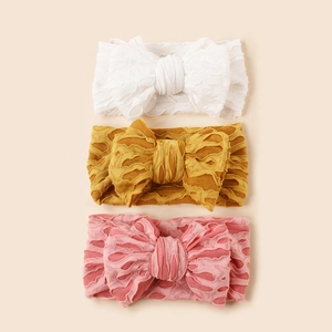 Détails de trois bandeaux élastiques pour bébé avec grands nœuds en blanc, jaune et rose