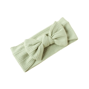 Elastic baby headband with large bow in soft light green ribbed knitted fabric