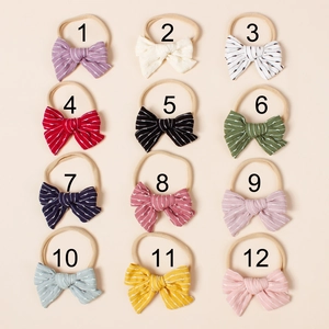 Set of 12 colorful striped and polka dot bow headbands for infants in a neat 3x4 grid display