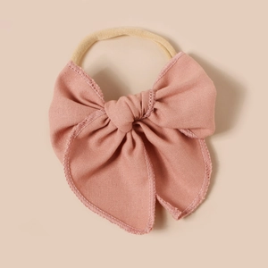 Détail du nœud en lin et du bandeau en nylon élastique de couleur vieux rose poudré