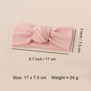 Detail view of pink ribbed baby headband with top knot and dimensions 17cm by 7.5cm