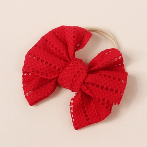 Close-up of baby headband featuring a red lace mesh bow and soft elastic band