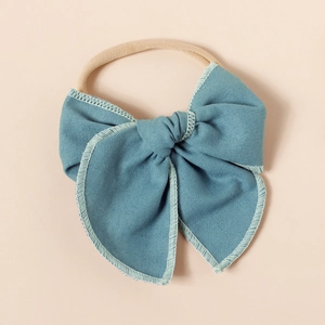 Détail d'un bandeau bébé en lin bleu montrant la couture fine et la bande élastique