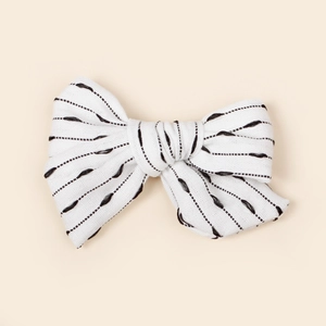 Détail d'une barrette à cheveux avec nœud en tissu rayé blanc et noir pour petites filles