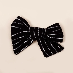 Détail du nœud à cheveux noir en maille avec des rayures blanches pointillées