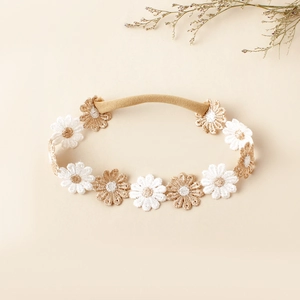 Détail du bandeau en nylon souple avec marguerites brodées en blanc et beige