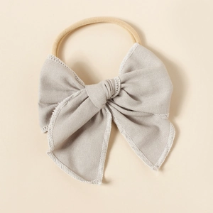 Détail du bandeau en lin pour bébé avec bande en nylon extensible et bordure cousue blanche