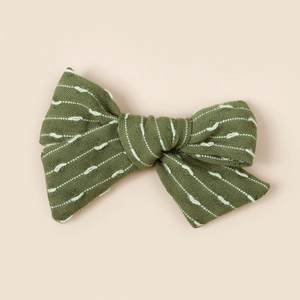 Détail du nœud papillon à rayures vert olive avec texture de tissu tissé