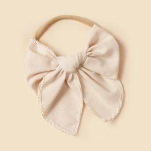 Détail du bandeau en lin blanc crème avec nœud papillon et bande en nylon pour petites filles