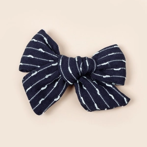 Détail d'un nœud papillon bleu marine pour filles avec broderie de pointillés blancs