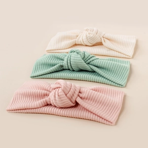 Close-up of ribbed knit baby headbands with knotted bow design in soft pastel colors