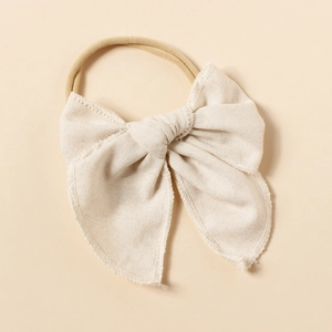 Détail de l'accessoire cheveux bébé en lin texturé avec bandeau élastique en nylon souple