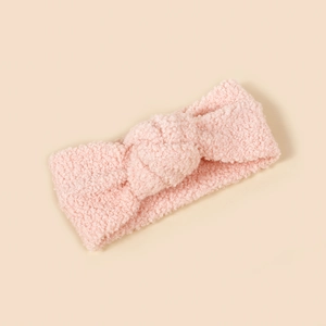 Nahaufnahme von rosa Lammwolle Baby Stirnband mit weicher Textur und Knotendetail