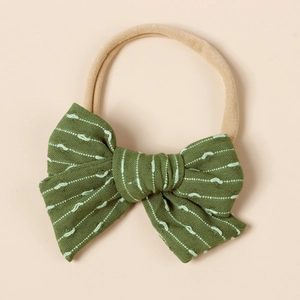 Close-up of baby nylon headband with dark green striped bow and embroidered wave nodes