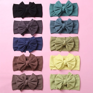 Detailed close-up of 10 ribbed fabric baby headbands with oversized bows in various colors