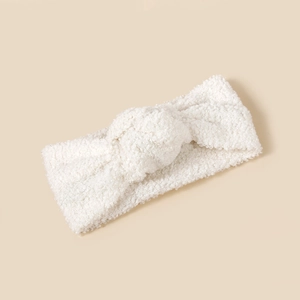 Nahaufnahme von weißem Baby-Stirnband aus Lammwolle mit weichem Knotendetail für Babys