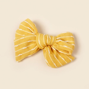 Détail d'un nœud papillon jaune rayé pour filles avec une texture tissée douce