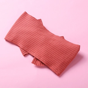 Knitted ribbed baby headband with 3D bow in rust red color on pink background