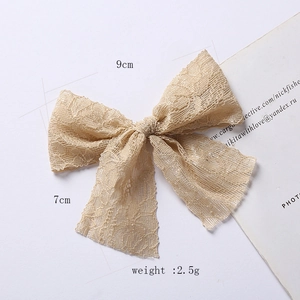 Détails de la pince à cheveux noeud en dentelle champagne, dimensions 9cm x 7cm sur blanc
