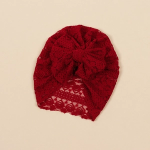 Detailed view of dark red floral lace baby turban hat with a large decorative bow