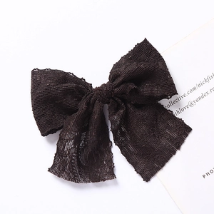 Vue détaillée d'une barrette nœud en dentelle multicouche avec texture mesh et bords festonnés