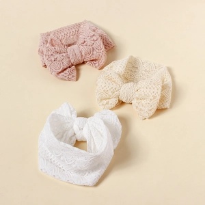 Detailed macro view of three lace bow baby headbands in pink, beige, and white colors