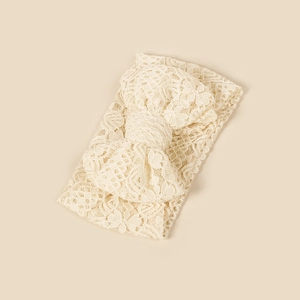 Detailed close-up of a floral lace newborn headband with a large cream bow