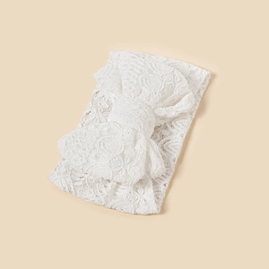 Close-up of the delicate floral embroidery on white lace bow for infant headbands