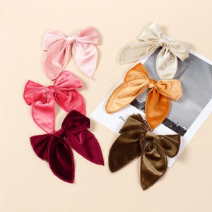 Close-up of velvet swallowtail bow hair clips in six vintage colors for girls