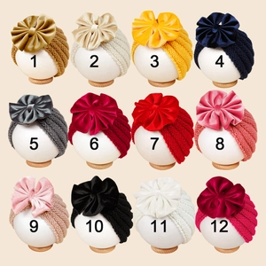 Dodici colori di cappelli a maglia per neonati con grandi fiocchi di velluto su teste