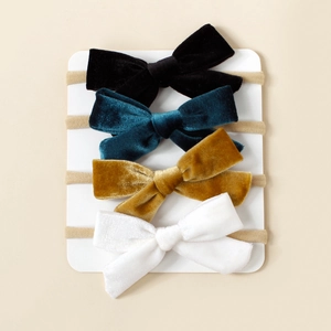 Détail d'un lot de quatre bandeaux en velours doux pour bébés en couleurs assorties