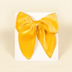 Detailed view of mango yellow velvet swallowtail bow hair clip on a display card