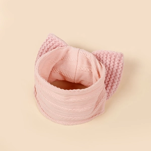 Pink knit baby headband with large double bow and warm textured cable stitch design